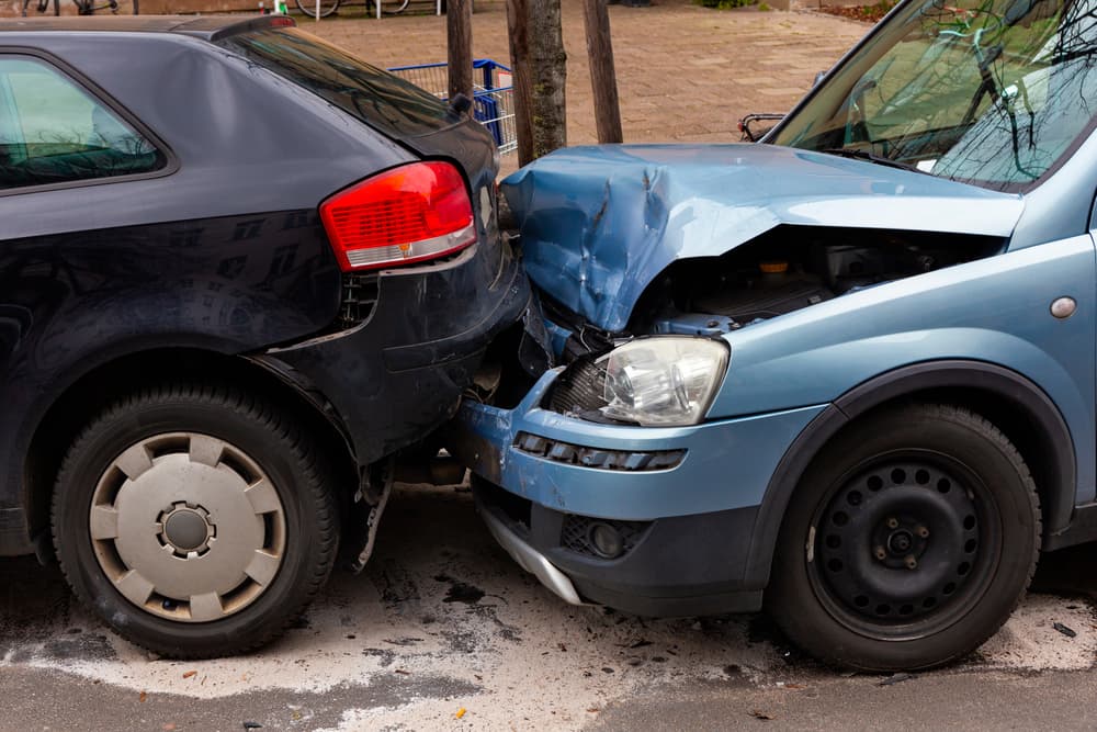 Rear-end car collision showing a vehicle with front-end damage after striking the back of another car, illustrating a common type of traffic accident.